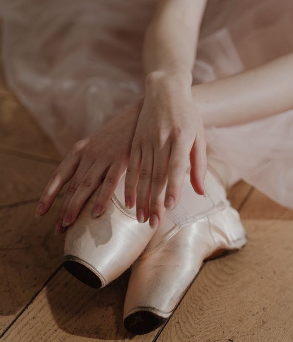 Woman in a graceful yoga pose with soft pink light accents.