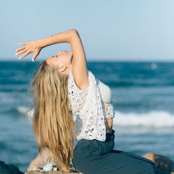 Woman meditating peacefully outdoors at sunrise.